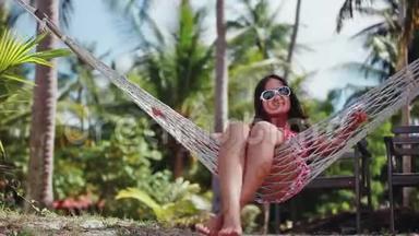 年轻快乐的女人戴着太阳镜躺在吊床上放松享受假期。 <strong>1920</strong>x1080